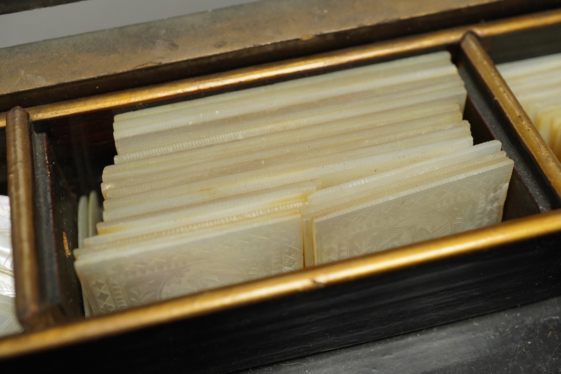 A 19th century Chinese export lacquer box containing assorted mother-of-pearl gaming counters and a 19th century Japanese lacquer box, largest 42.5cm wide. Condition - fair